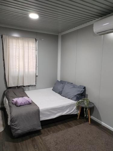 a small bedroom with a bed and a chair at The Vanilla Cabin 1 in Kampung Tok Jembal