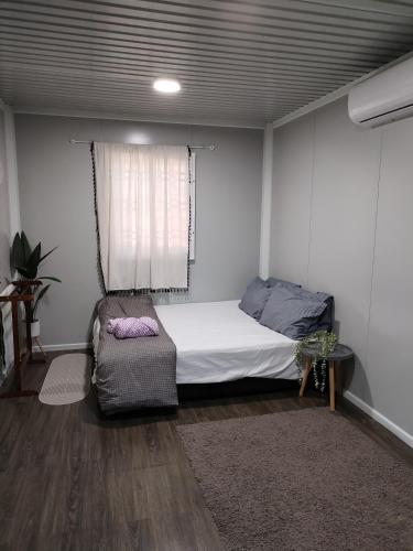 a bedroom with a bed and a chair in it at The Vanilla Cabin 1 in Kampung Tok Jembal