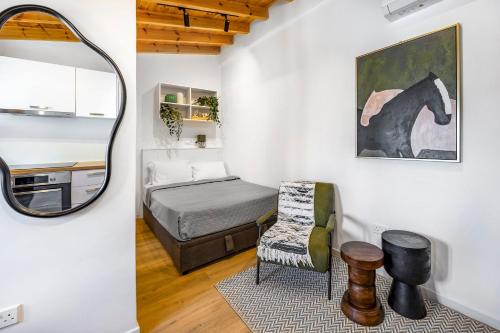 a bedroom with a bed and a chair and a mirror at Olga Premium Apartments in Limassol