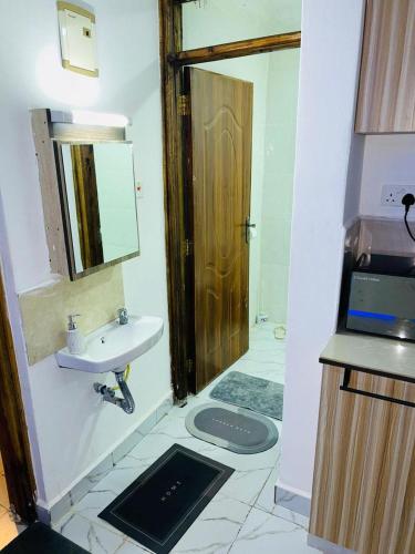 a bathroom with a sink and a toilet and a mirror at GRANDE BnBs in Nanyuki