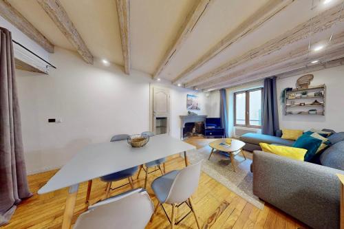 un salon avec une table, des chaises et un canapé dans l'établissement Le Cocon Rousseau - Pretty T2 in Old Town, à Annecy