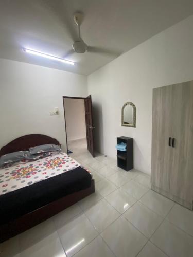 ein Schlafzimmer mit einem Bett und einer Decke in der Unterkunft Wan Homestay in Kuala Terengganu