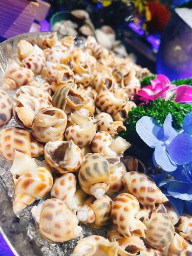 a pile ofcooked shells on a plate with flowers at 开芯国际大酒店 in Guangzhou
