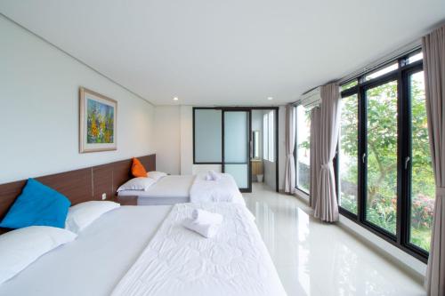 une chambre avec deux lits et de grandes fenêtres dans l'établissement Family Only Large Backyard Villa - De Reiz Kencana Syariah 4BR, à Ciburial