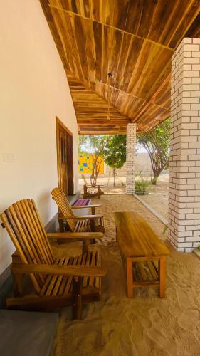 a patio with two chairs and a table and a table and benches at Kadjan villa in Arugam Bay