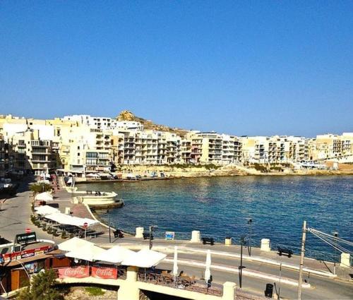vistas a una ciudad con edificios y agua en Uwejja Boutique House Marsalforn seafront, en Marsalforn