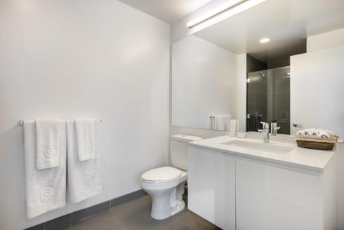 a white bathroom with a toilet and a sink at Rincon Hill 1BR w Gym Steam Room nr SVB FB SFO-208 in San Francisco