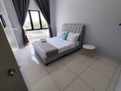 a bedroom with a bed and a window and a table at The Horizon by MyKey in Ipoh