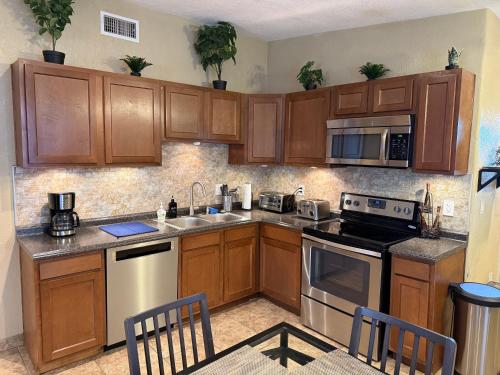 a kitchen with wooden cabinets and stainless steel appliances at 3 Bedroom, 2 Bath Whole House, Arizona State Univ, Tempe, Mesa Scottsdale on Light Rail, Dogs ok, Work Space in Mesa
