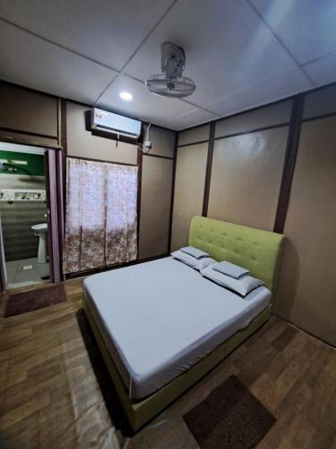 a bed in a small room with a tv at Benteng Taman Negara in Jerantut