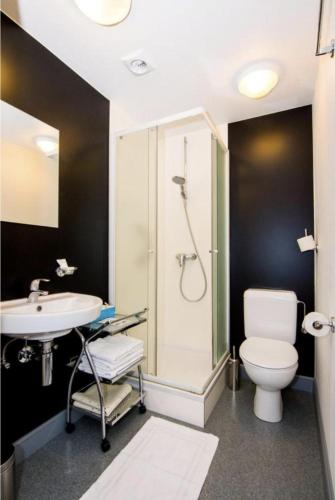 a bathroom with a shower and a toilet and a sink at Gillis Eight Guest Rooms by Romy&Travis in Bruges