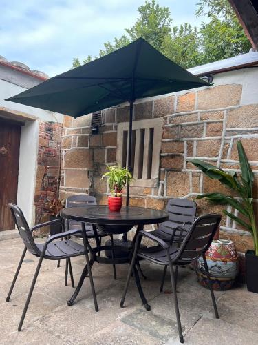 a black table with chairs and an umbrella at 心如所院民宿 in Hsia-shih