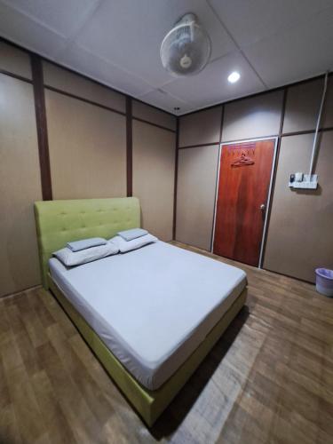 a large bed in a room with a wooden cabinet at Benteng Taman Negara in Jerantut