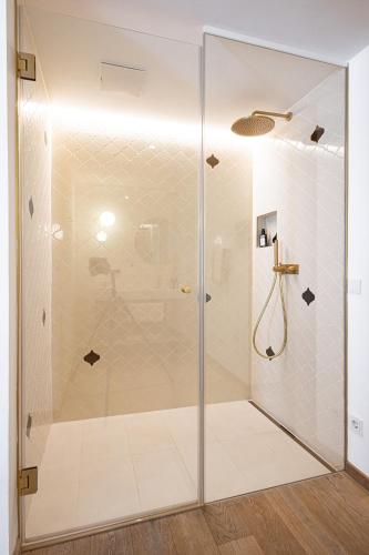a shower with a glass door in a bathroom at Boutiquehotel Zum Goldenen Hirschen in Gmunden