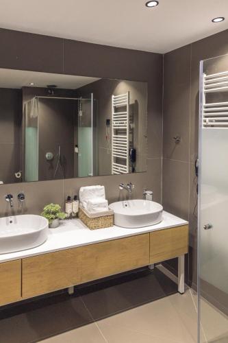 a bathroom with two sinks and a mirror at Kamengrad Hotel & SPA in Panagyurishte