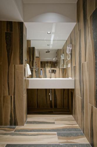 a bathroom with a sink and wooden walls at Golden Plaza in Ahmedabad