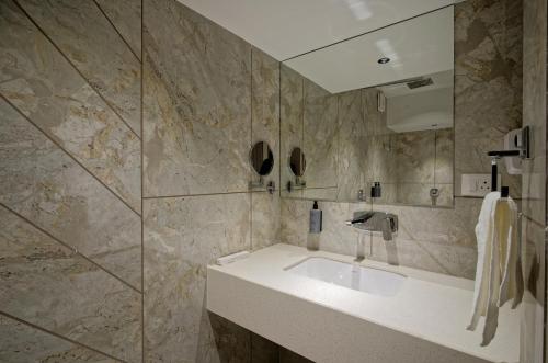 a bathroom with a sink and a mirror at Golden Plaza in Ahmedabad