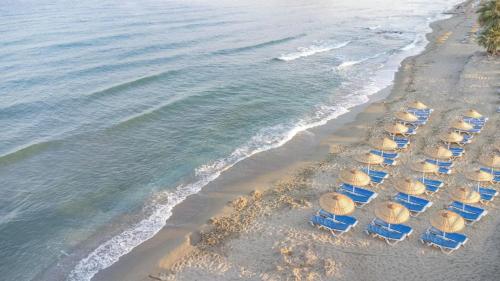 a group of chairs and umbrellas on a beach at PROXIMA HOTEL Kuşadası in Kusadası