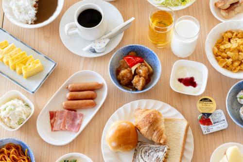 a table with plates of food and a cup of coffee at Hotel Matsumoto Yorozuya in Matsumoto