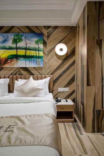 a bedroom with a bed and a painting on the wall at Golden Plaza in Ahmedabad