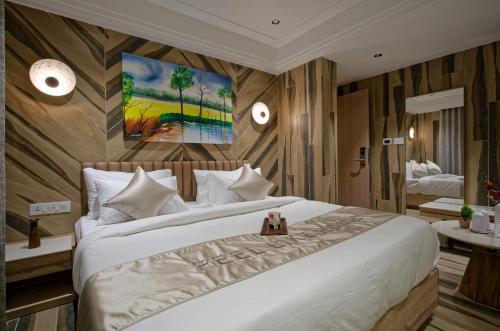 a bedroom with a large bed and a painting on the wall at Golden Plaza in Ahmedabad