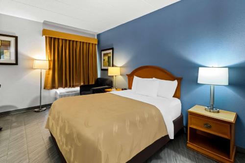 a hotel room with a large bed and a chair at Quality Inn & Suites CVG Airport in Erlanger