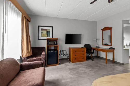 a living room with a couch and a desk and a television at Quality Inn & Suites CVG Airport in Erlanger