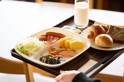 a tray with a plate of food on a table at Hotel Matsumoto Yorozuya in Matsumoto