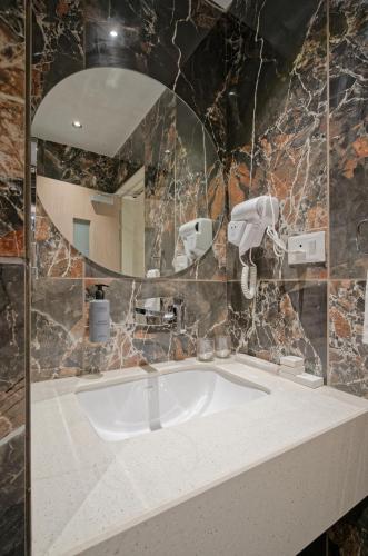 a bathroom with a sink and a mirror at Golden Plaza in Ahmedabad