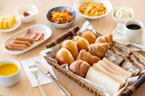 a table with a tray of pastries and other breakfast foods at Hotel Matsumoto Yorozuya in Matsumoto