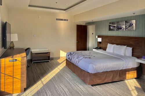 a hotel room with a bed and a flat screen tv at Sleep Inn Oakbrook Terrace - Chicago in Oakbrook Terrace