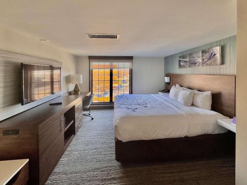 a hotel room with a large bed and a desk at Sleep Inn Oakbrook Terrace - Chicago in Oakbrook Terrace