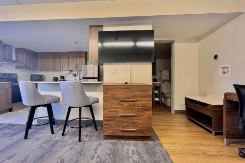 a kitchen with two bar stools and a counter top at Sleep Inn Oakbrook Terrace - Chicago in Oakbrook Terrace
