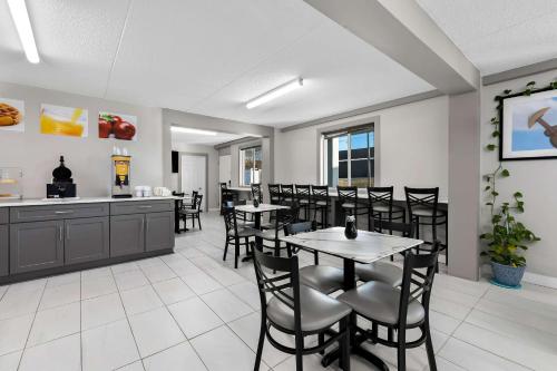 a dining room with tables and chairs and a kitchen at Quality Inn Nashville - Opryland Area in Nashville