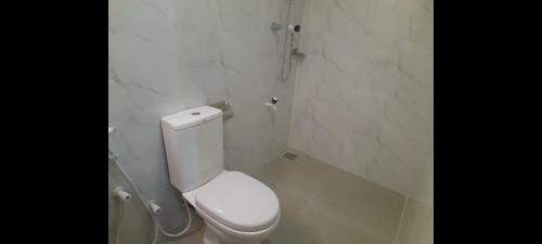 a white bathroom with a toilet and a shower at Gloria Cottage Non AC in Negombo