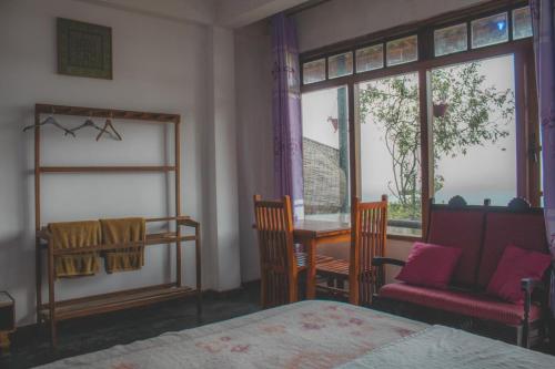 a bedroom with a bed and a chair and a window at Il Villino haputale in Haputale