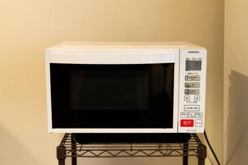 a microwave oven sitting on top of a rack at Hotel Matsumoto Yorozuya in Matsumoto