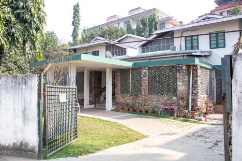 a house with a fence in front of it at The timeless Haven Heritage bungalow in Guwahati