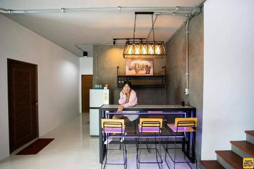 a woman sitting at a table in a kitchen at Winlanee Pool Villa Hatyai in Ban Khlong Toei (1)