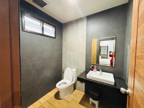 a bathroom with a toilet and a sink and a mirror at Winlanee Pool Villa Hatyai in Ban Khlong Toei (1)