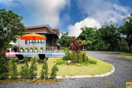 a house with an orange umbrella in front of it at Winlanee Pool Villa Hatyai in Ban Khlong Toei (1)