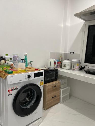 y cocina con lavadora y encimera. en Small home, en Ban Khlong Hok Wa