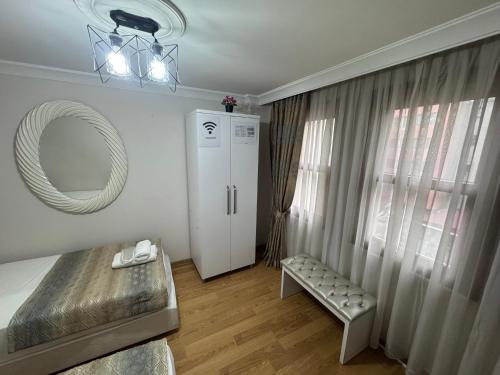 Cette chambre comprend un réfrigérateur, un banc et un miroir. dans l'établissement Rosalie Palace, à Istanbul