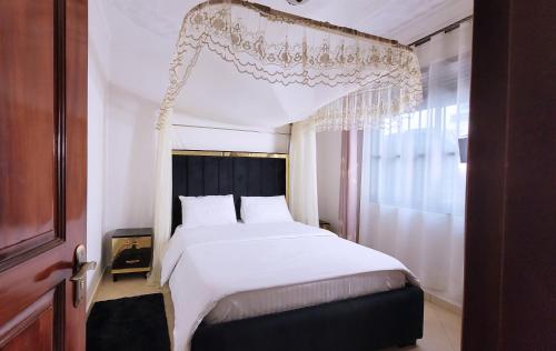 a bedroom with a large white bed and a window at Lovana Apartments and Hotel, Gulu City in Gulu