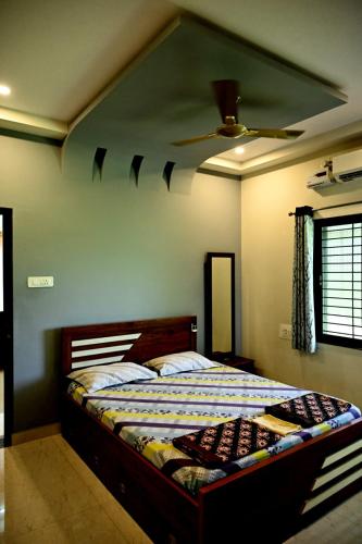 a bedroom with a bed with a ceiling fan at Providence homestay malpe in Udupi