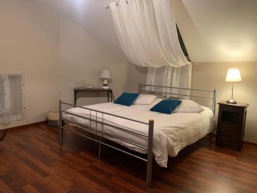 a bedroom with a bed with blue pillows at MAISON Cornimont in Cornimont