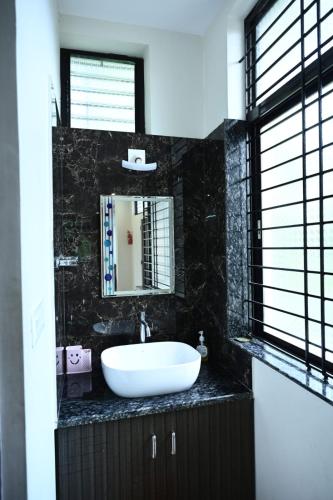 a bathroom with a white sink and a mirror at Providence homestay malpe in Udupi
