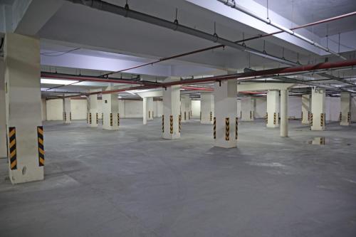 an empty parking lot with white columns in a parking garage at Hotel Elegant inn By Nexottel Vesu in Surat