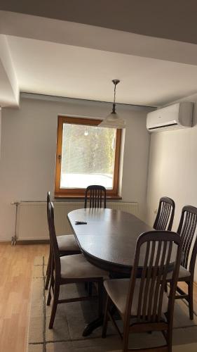 a dining room with a table and chairs and a window at BT Lux apartment 2 in Skopje