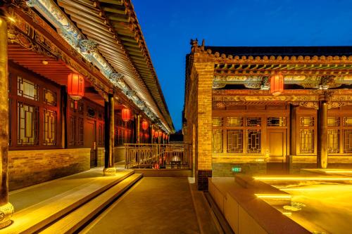 a courtyard of a building with red lanterns at Xinghuacun Hotel in Pingyao
